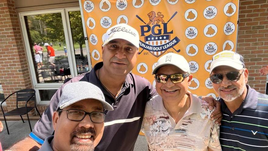 Golfers gathered outside the clubhouse beside the Punjabi Golf League backdrop