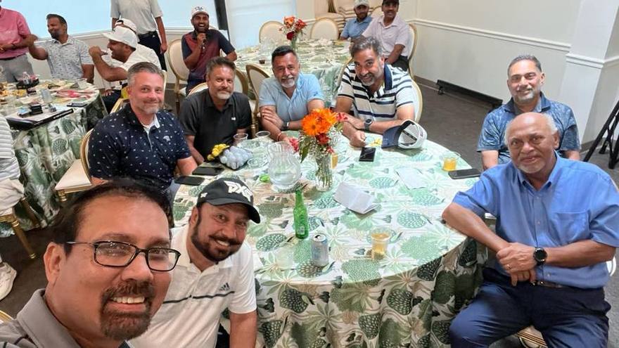 Golfers seated around a dinner table in the evening